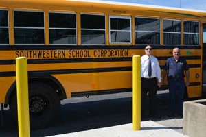 Southwestern Jefferson County School District Superintendent Trevor Jones, left, stands in front of one of the district's new autogas buses.