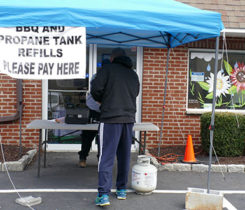 A retailer helps a customer outside a closed office building. Photo by Roger Rosenbaum