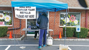 A retailer helps a customer outside a closed office building. Photo by Roger Rosenbaum.