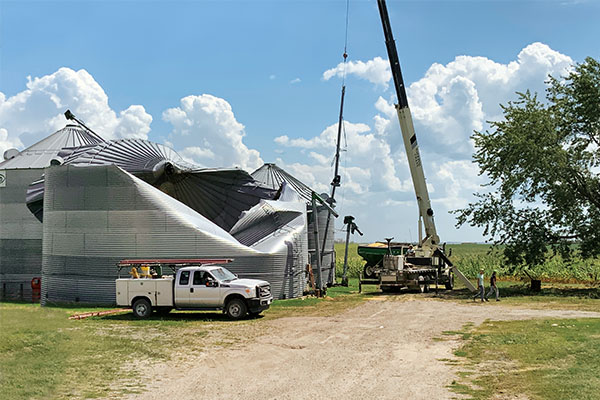 A crane operator prepares to remove grain bins damaged by the derecho near the town of Van Horne in east-central Iowa. Photo by Jay Christie