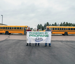 From left: Lance Gerry, school mechanic, Harrisburg, S.D.; Russ Nelson, school mechanic, Lennox, S.D.; and Eric Kracke, CHS certified energy specialist, are advocates of the transition to propane-fueled school buses. Propane buses in front of the 12,000-gallon bullet at the Harrisburg fill station. (Photo: CHS, Inc.)