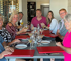 Andrew Hartmann, center, celebrates with friends and family at the closing dinner. (Photo courtesy of Cetane Associates)