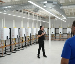 Navien Director of Training Matt Curro leads a facility tour into the plumbing and hydronics room at the new Innovation Center and Training Academy in Irvine, California. (Photo courtesy of Navien Inc.)